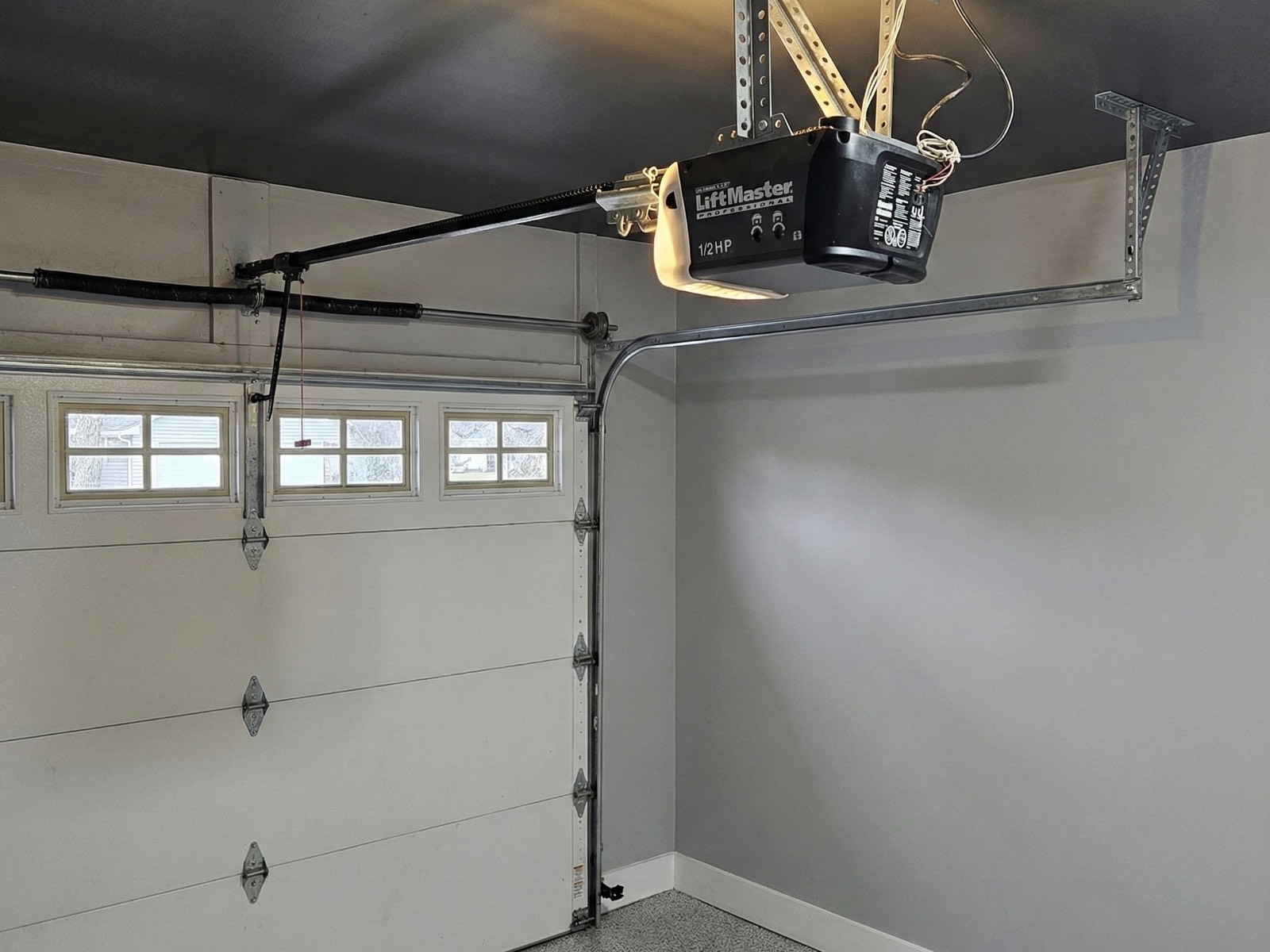 Chain-drive garage door opener and rail mounted in an attached garage